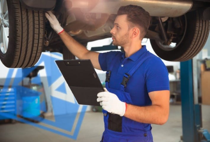 Confident and concentrated young and experienced car repair specialist with a tablet in his hand inspects and diagnosis the car for breakdowns
